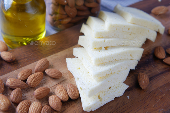 Close up of cheese and almond nut on table.
