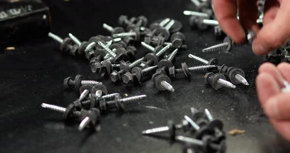 Man hands take in handful Roofing self-tapping screws
