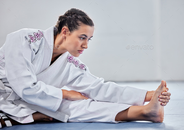 Martial arts, fitness and stretching with woman in karate school for training, sports and fight per