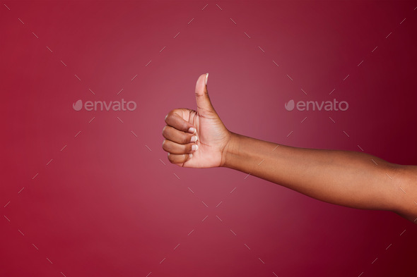 Thumbs up, yes and agreement hand sign of a black woman showing support, motivation and success. Th