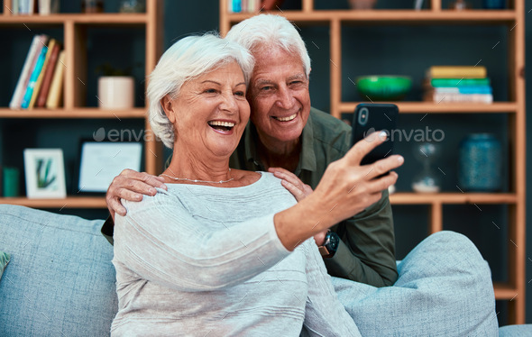 Senior couple, selfie and video call with phone in living room, lounge or family home. Happy, elder