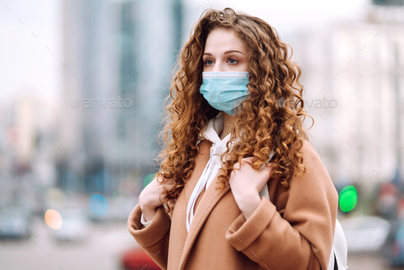 Woman in protective medical mask on her face on the street. Woman, wear face mask. Corona virus.