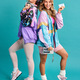 Were out spreading some 80s vibes. Studio shot of two beautiful young women  styled in 80s clothing. Stock Photo