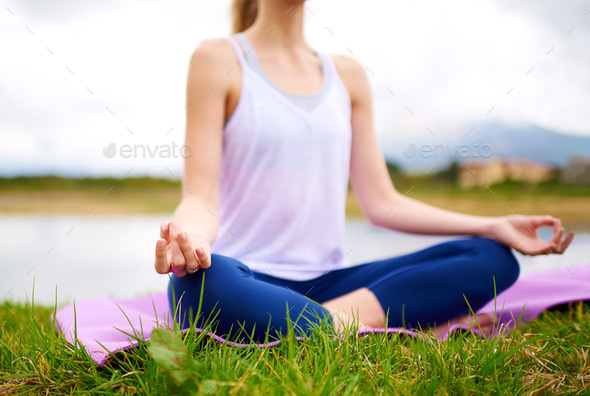 Life is a balance of holding on and letting go. Shot of a young woman doing yoga outdoors.