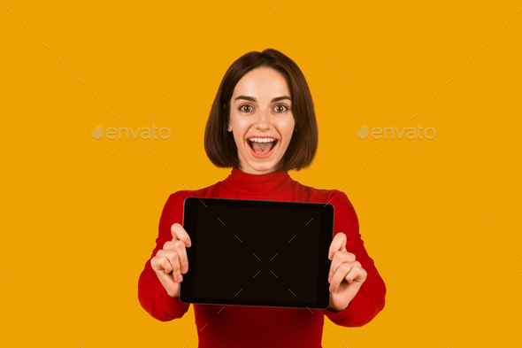 Excited attractive lady showing digital tablet with blank screen