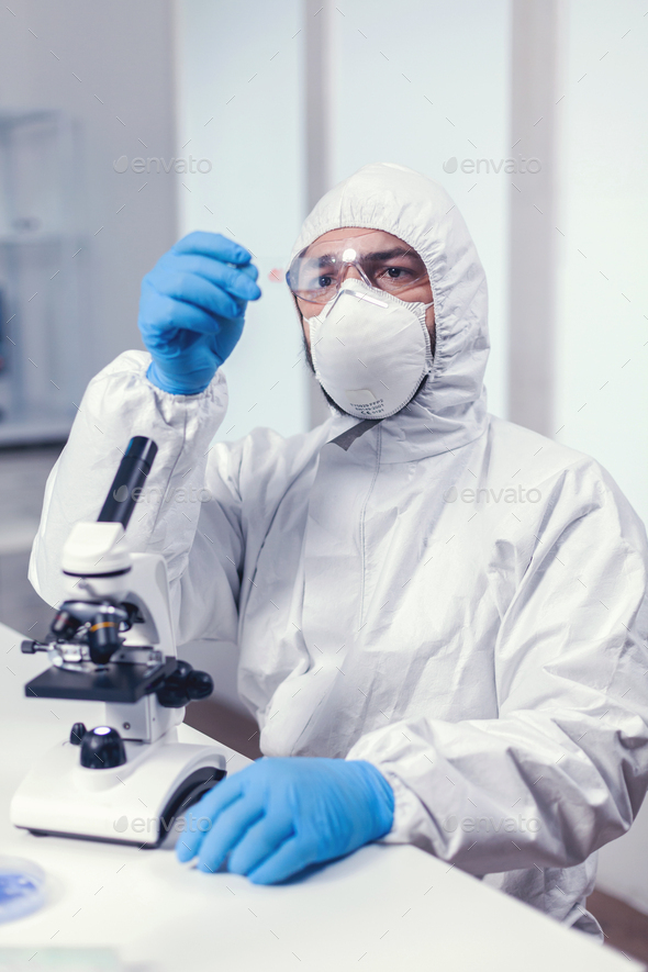 Medical engineer looking attentive at sample on glass slide