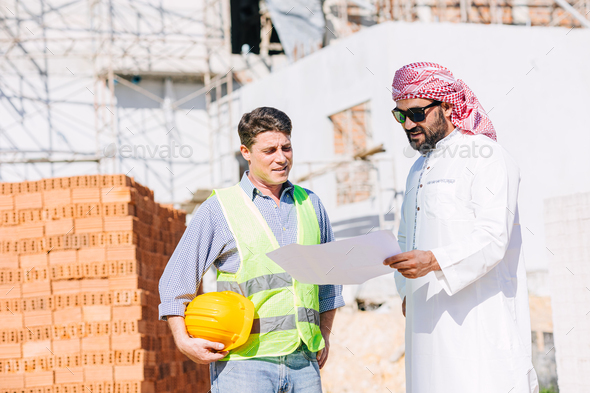 Construction builder working with Arab man project manager real estate investor for new building