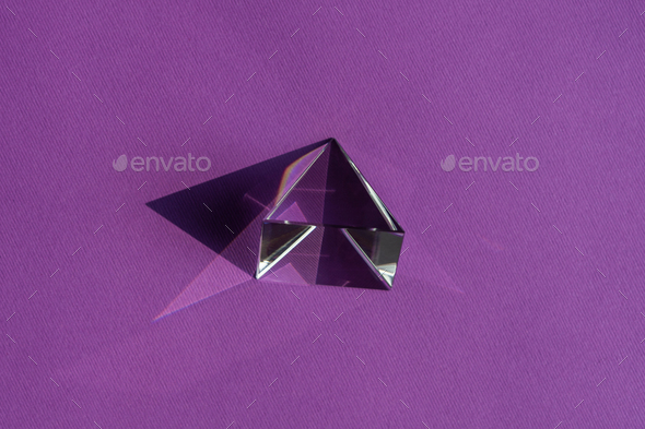 Crystal prism refracting light, magic crystals and pyramid, sphere and cube on purple background