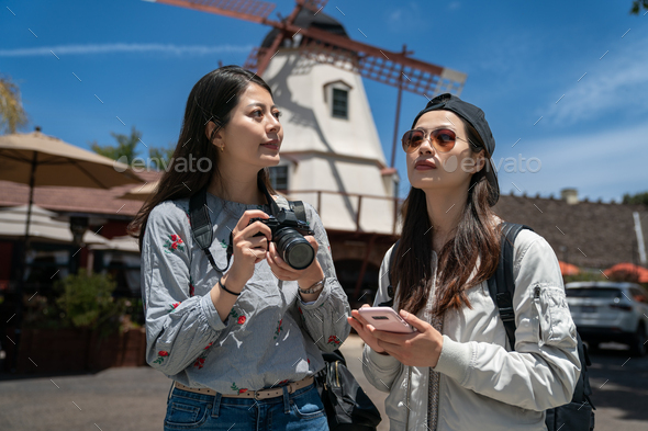 two girls looking at opposite ways near windmill