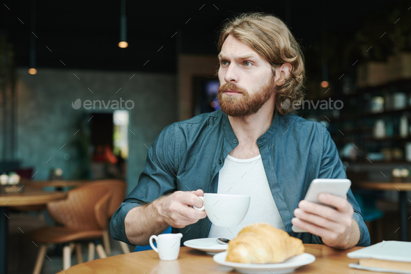 Handsome guy drinking coffee in cafe