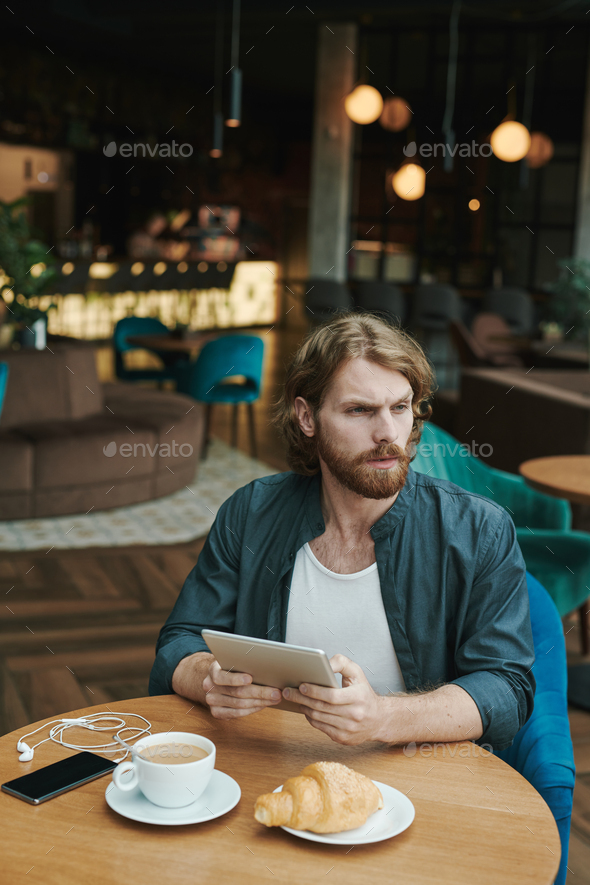 Handsome guy drinking coffee in cafe
