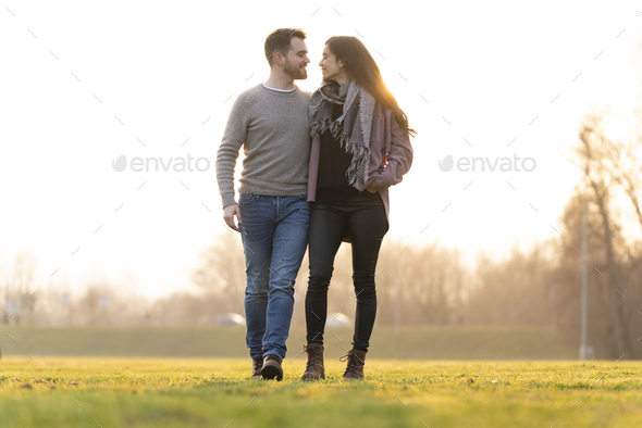 Young couple walking and looking at each other in a park on san valentine\'s day