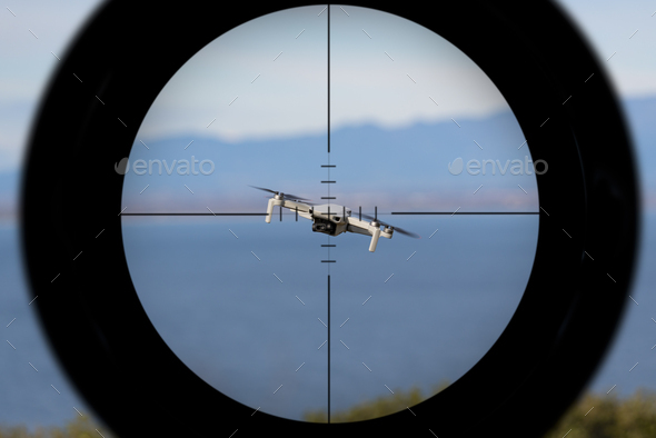 Gun sight pointing at a drone flying with the ocean in the background