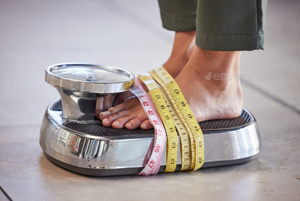 Diet, weight loss and feet of a woman on a scale for body check, measure and balance to lose weight