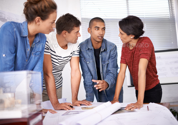 Explaining his design concept. Shot of a group of young designers ...