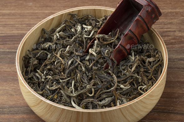 Bowl with dried Chinese Monkey King of Jasmin tea leaves close up