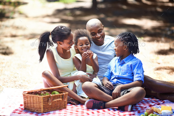 Spending some family time outdoors. Shot of a family enjoying a picnic in the woods.