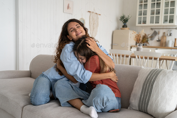 Smiling supportive young mother hugging cuddling teen daughter, mom ...