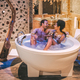 Happy interracial couple relaxed in the jacuzzi enjoying their self and drinking wine - PhotoDune Item for Sale