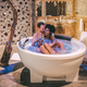 Happy interracial couple relaxed in the jacuzzi enjoying their self and drinking wine - PhotoDune Item for Sale