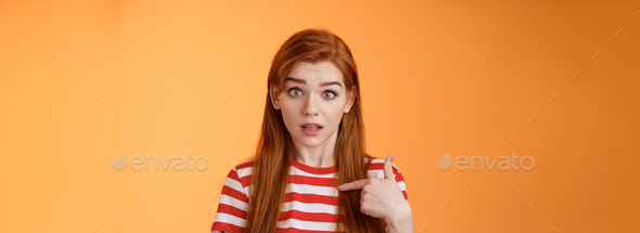You mean me. Surprised redhead woman pointing herself puzzled raise eyebrows questioned, look full