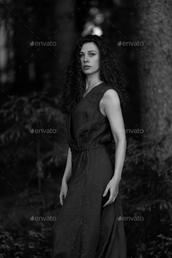 Young, beautiful skinny brunette posing in a forest grove. Young country girl in a classic sundress