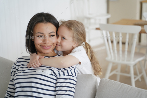 Little preschool daughter cuddling foster mother, showing love ...