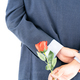 Businessman in suit  holding red roses behind his back - PhotoDune Item for Sale