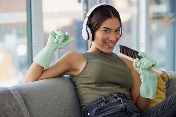 Spring cleaning, singing and woman, portrait and music, headphones and fun in living room, lounge a