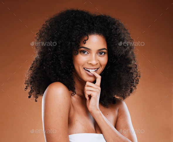 Face, beauty and black woman bite finger in studio isolated on brown background. Portrait, skincare