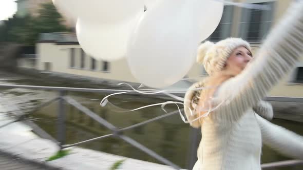 Slow motion young beautiful blonde woman running holding balloons alt
