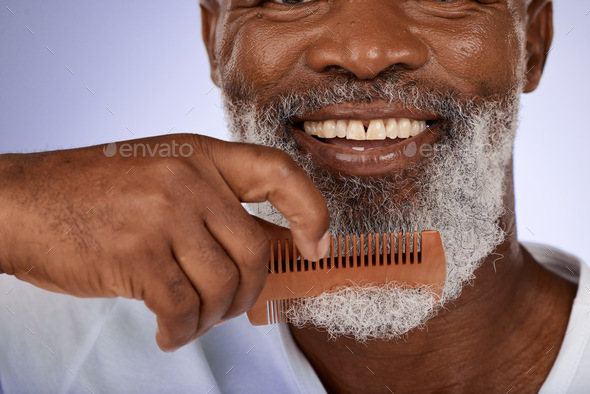 Senior man, face and beard comb in studio isolated on a purple background. Hair care, smile and wel