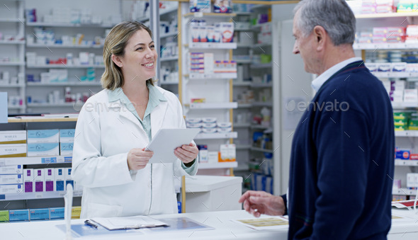 Shot of a young pharmacist handing out a prescription to a senior citizen  at a pharmacy Stock Photo by YuriArcursPeopleimages