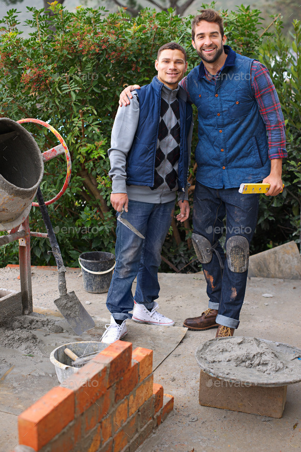 Hes going to be a master builder one day. Portrait of a bricklayer and his apprentice at work.