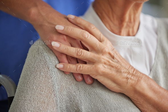 Closeup, hand and nurse with senior for care in wheelchair at house, nursing home or retirement. Zo