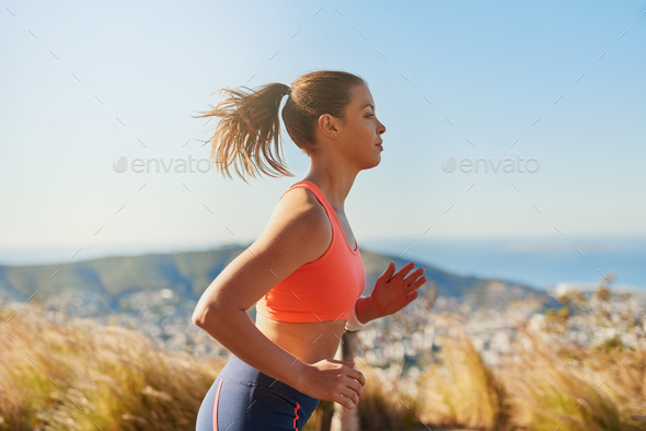 Keep moving forward. Cropped shot of an attractive young woman running in the early morning.