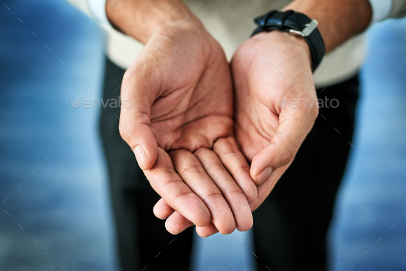 Closeup of an unrecognizable person reaching out with their open hands against a blue background