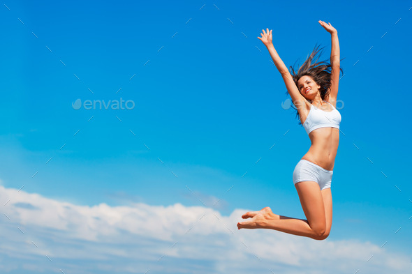 Happy the higher I go. Shot of a happy young woman jumping high in the sky. - Stock Photo - Images