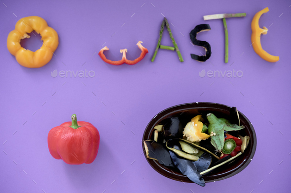 pieces of edible vegetables forming the word zero waste next to a bowl with the skins of an eggplant - Stock Photo - Images