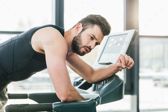 exhausted sportsman working out on treadmill at sports center