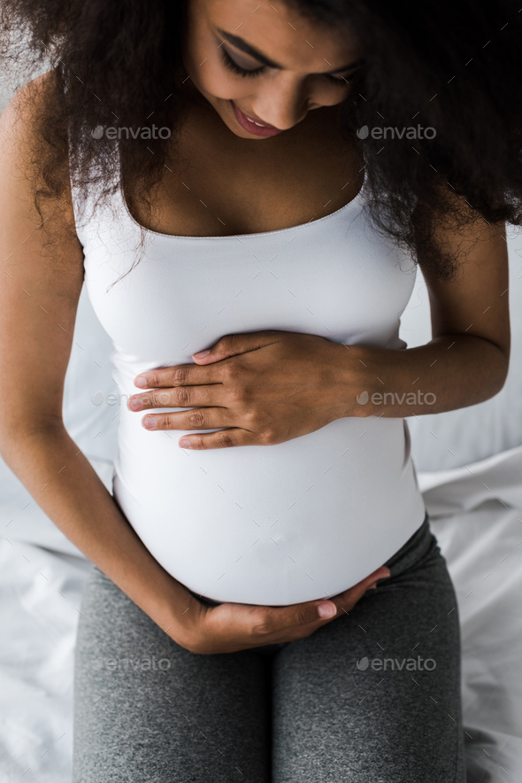 overhead view of positive curly african american pregnant woman