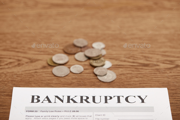 bankruptcy form and metal coins on brown wooden table Stock Photo by  LightFieldStudios
