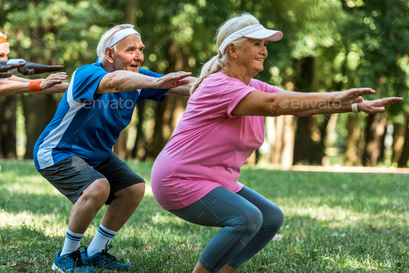 happy multicultural retired people doing sit ups on grass Stock Photo ...