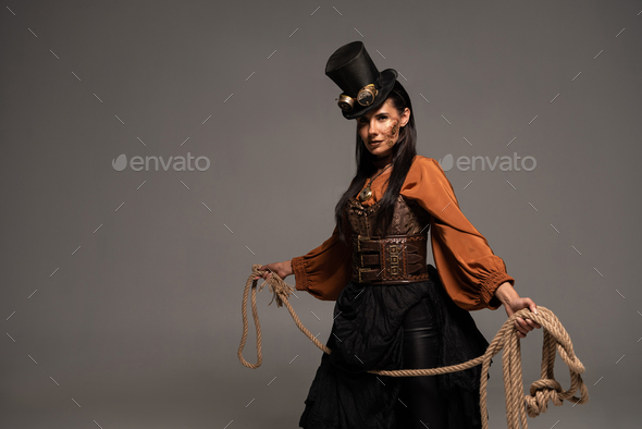 attractive steampunk girl in top hat holding lasso isolated on grey