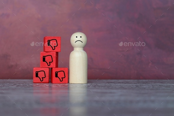 Sad wooden doll and thumbs down icon.