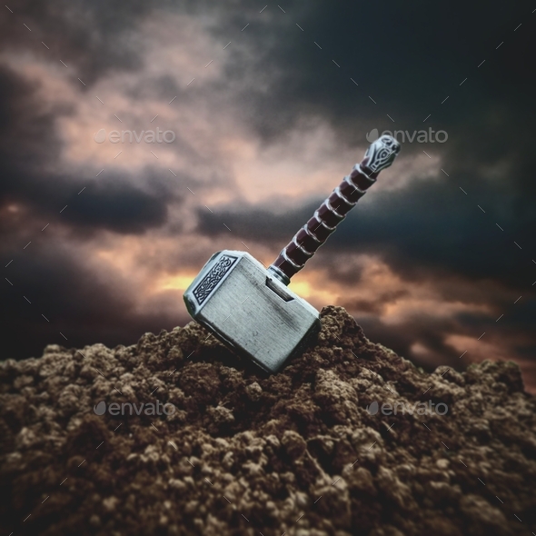 Close up shot of the hammer of Thor stuck in the ground Stock Photo by