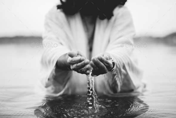 Closeup Shot Of Jesus Christ Holding Water With His Palms In Black And