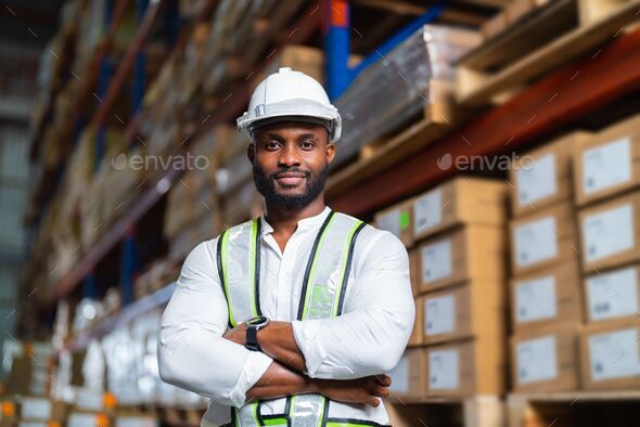 Portrait of a black warehouse manager standing in a large distribution center - a concept of career