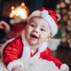 Cheerful infant in Santa clothes smiling at the camera - PhotoDune Item for Sale