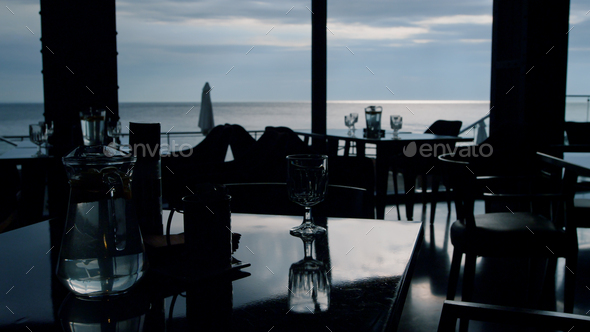 Evening sea view in stylish restaurant. Served event tables in lounge hotel bar